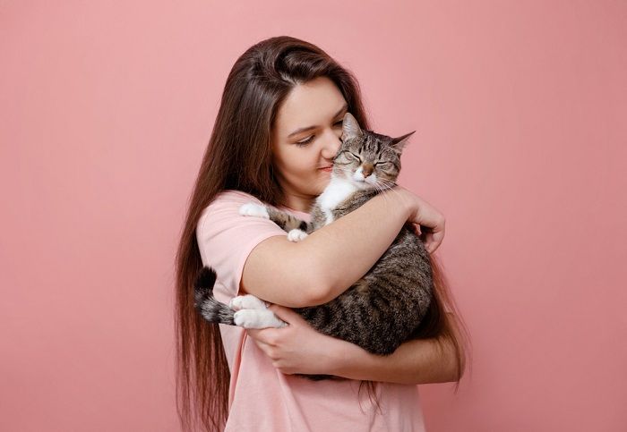 Um doce momento capturado quando um gato abraça carinhosamente seu dono, demonstrando carinho e companheirismo.