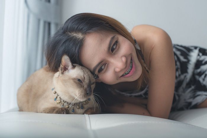 mulher e gato deitados no sofá