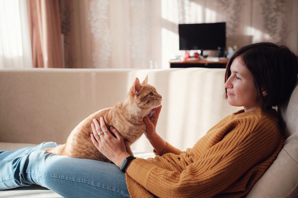 mulher descansando com animal de estimação no sofá